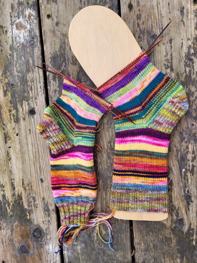 bunt geringelte Socken eine auf dem Sockenbrett bis zur Mitte des Fusses gestrickt